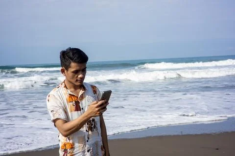 Garut, West Java – 2024, May 22: asian young man is taking photos using a phone Stock Photos