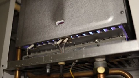 Gas boiler heats water while steady blue flames burn inside the unit Stock Footage 344055412