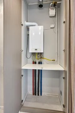 Gas boiler installed inside open utility cabinet Stock Photos