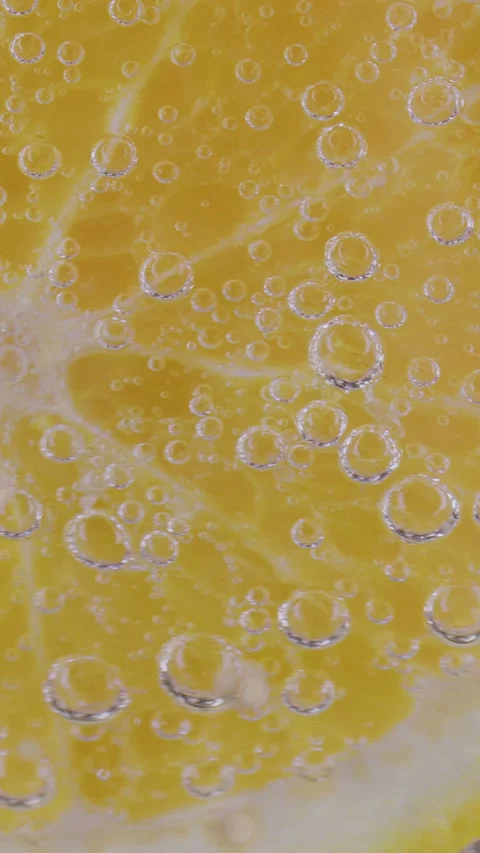 Gas bubbles rise up the yellow lemon Vídeo Stock 237706151