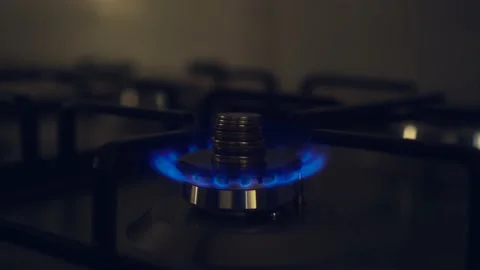Gas burner flame turn off with stack of coins. Kitchen stove blue fire switching Stock Footage 208865315