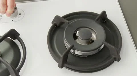 A gas cooked being turned on and a pot of water being placed upon it Stock Footage 24634629