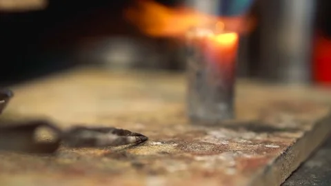 Gas flame flow softens the metal on a wooden table Stock Footage 72964822
