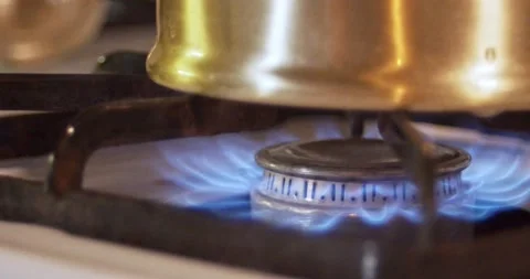 Gas grill stove being ignited under a golden teapot Stock Footage
