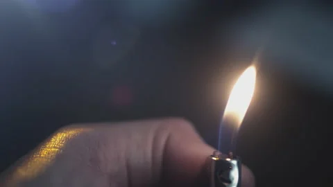 A gas lighter in a man's hand lights up in slow motion. A flame of fire Stock Footage 160503178