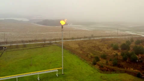 The gas pipe is located in the field. There is a fire burning in it. Extraction Stock Footage 204916789