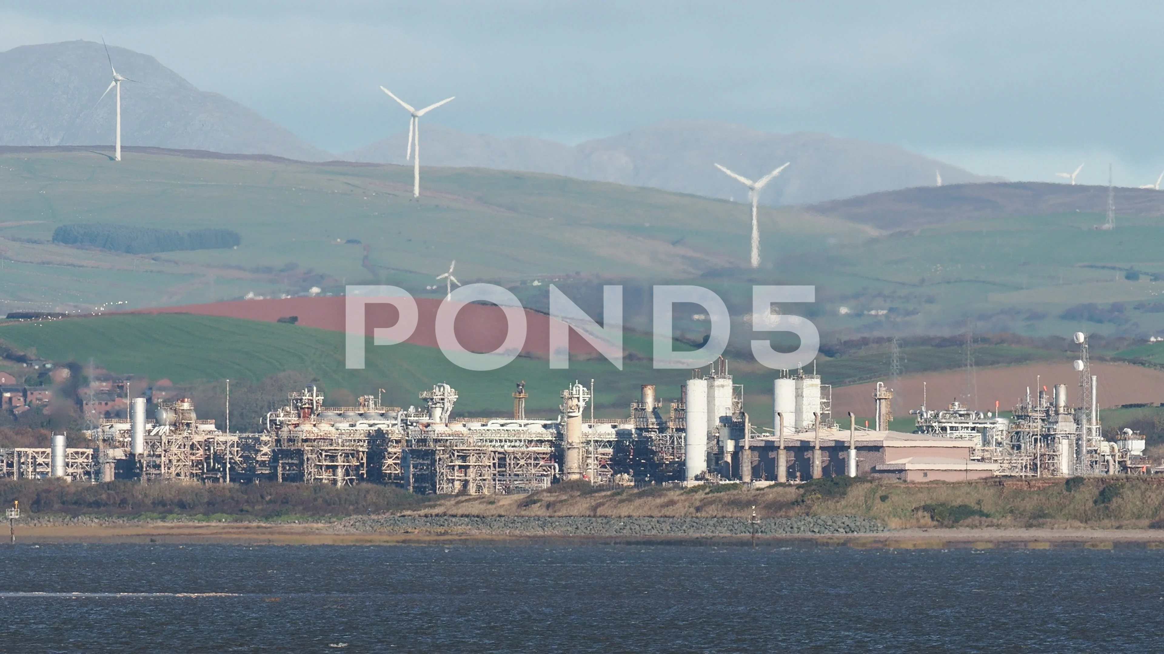 A gas plant in Barrow in Furness Cumbrias UK with wind turbines behind