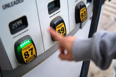 Gas pump choices of different octane ratings. Intentional blurry hand indicat Stock Photos