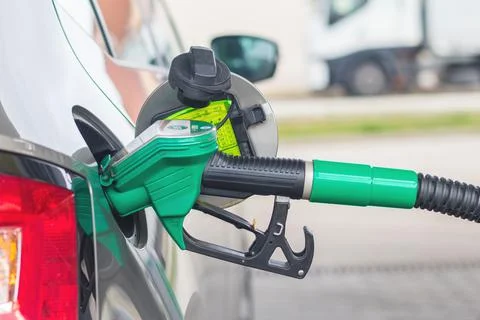 Gas pump nozzle at gas station, filling the car with petrol Stock Photos