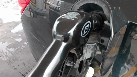 Gas Pump nozzle hose removed from gas tank of black car Stock Footage 128561044