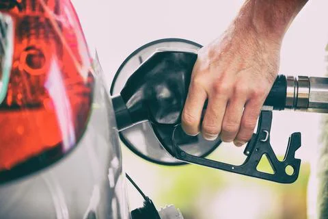 Gas pump person pumping fuel filling car tank at gas station. Man hand holding Stock Photos