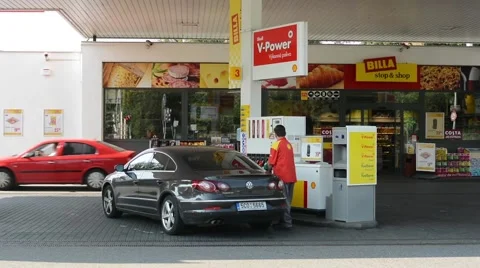Gas station (oil pump) Shell in the city -with cars and people:worker of station Stock Footage 40744054