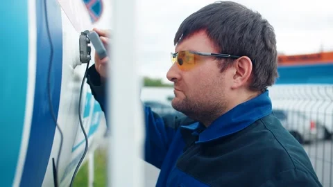 A gas station worker inspects the technical readings of a liquid propane tank Stockbeeldmateriaal 312964221