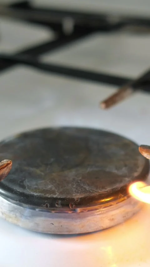 Gas stove burner igniting with a bright orange flame turning into a stable blue Stock Footage 341677449