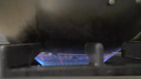 Gas stove flame heating pot inside professional kitchen Stock Footage 340152078
