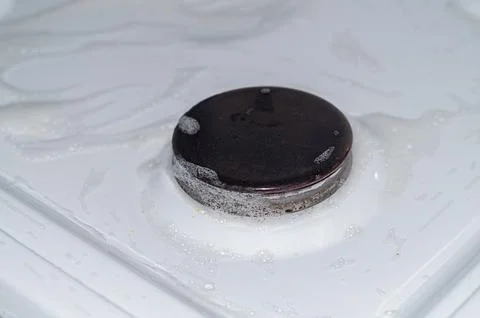Gas stove surface with sprayed cleaning agent to pre-dissolve dirt. The proce Stock Photos
