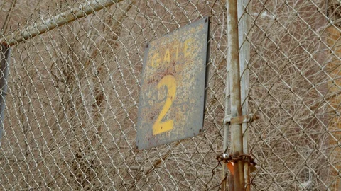 Gate 2 close up. Barbed wire chain link fence closed in industrial area. 4k60p Stock Footage 130146611