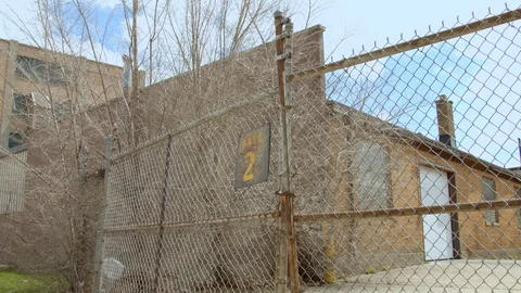 Gate 2 is closed. Barbed wire chain link fence closed in industrial area. 4k60p Stock Footage 130145503
