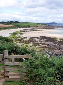 Gate on Coastal path with view of stunning beach, Cornwall, UK Stock Photos