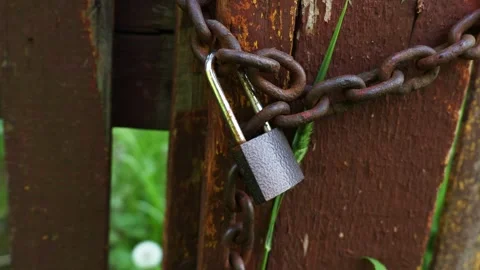 Gate is locked with chain and padlock. Rusty lock on a metal chain Stock Footage 278124760