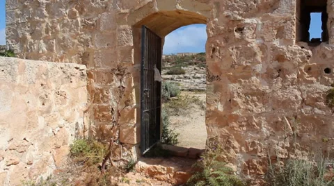 Gate In old wall with notices blowing in the wind from inside Video stock 33802099