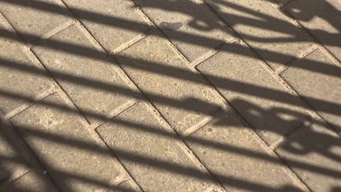 Gate shadow opens to sidewalk tile Stock Footage 70955798