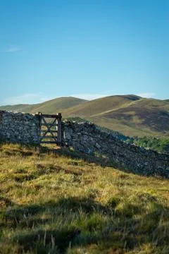 A Gate in a Stone Wall On a Path in Remote Scottish Countryside With Hills an Stock Photos