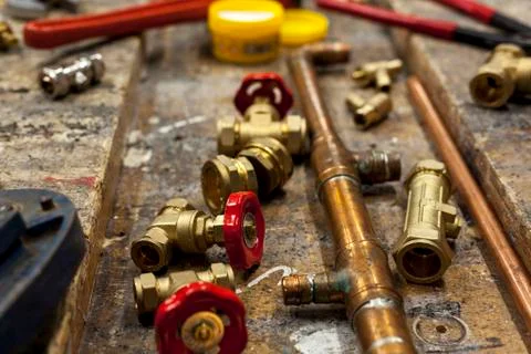 Gate valves and copper pipe on a wooden workbench 스톡 사진