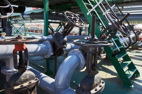 Gate valves and pipelines on the deck of an oil tanker Stock Photos