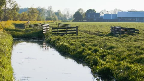 Gates on a pasture with a farm in the background 스톡 동영상 129642022