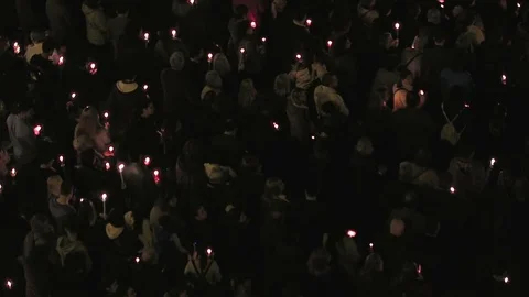 Gathered crowd holding candles at night. Stock Footage