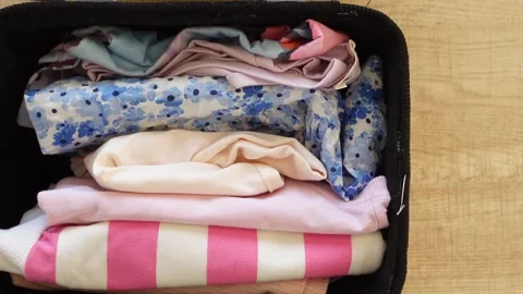 Gathering and arranging various fabric pieces in a neat container Stock Footage 301939655