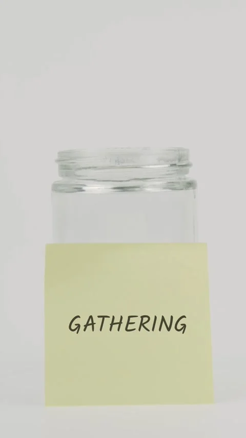 Gathering text or word on yellow sticky note attached to glass jar with hand Stock Footage 311738133