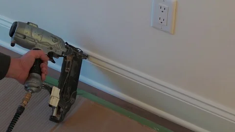 Gauge Finish Nailer man nailed slats custom house building contractor up a wall Stock Footage