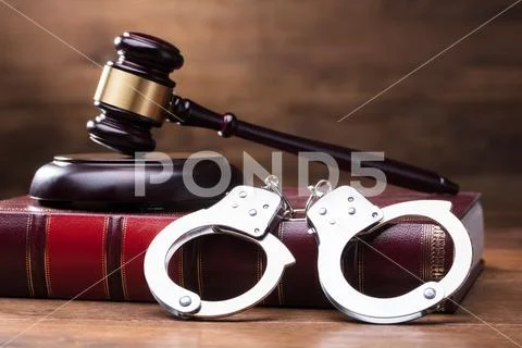 Gavel And Handcuffs On Law Book Stock Photos