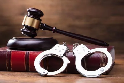 Gavel And Handcuffs On Law Book Stock Photos