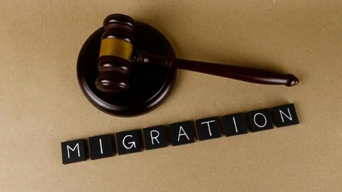 Gavel and MIGRATION text representing legal immigration concepts Stock Photos