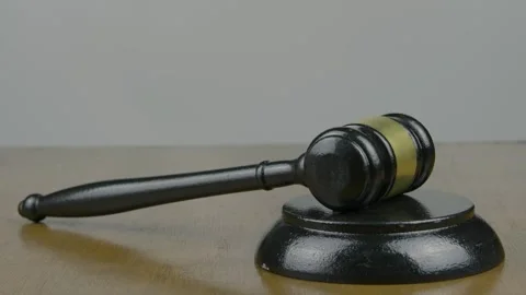 A gavel resting on a table, picked up, and struck once, then three times Stock Footage 303539893