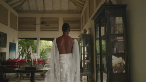 Gay bipoc man walks through luxury retro villa with vintage furniture in white Stock Footage 250358006