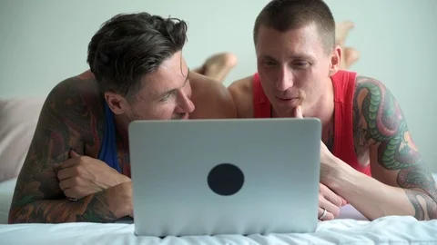 Gay couple in bed using laptop computer. Hugging. Stock Footage 105322958