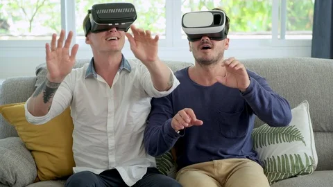 Gay couple relaxing on couch using virtual reality device. Looking around. Stock Footage 105316037