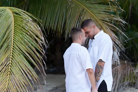 Gay couple standing while looking at each other tenderly and closely outdoors Stock Photos