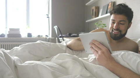 Gay couple using tablet in bed Stock Footage 51331847