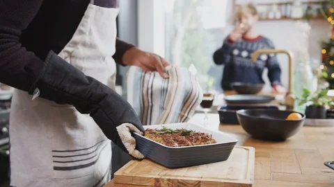 Gay Male Couple In Kitchen Cooking Dinner On Christmas Day Taking Vegetarian Nut Stock Footage