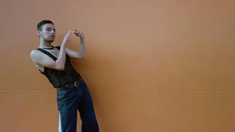 Gay man dancing with hands elegantly on orange background. Hands performance Stock Footage 192078070