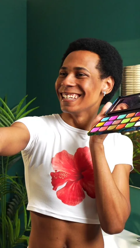 Gay man using mobile phone while recording makeup tutorial Stock Footage 292223486