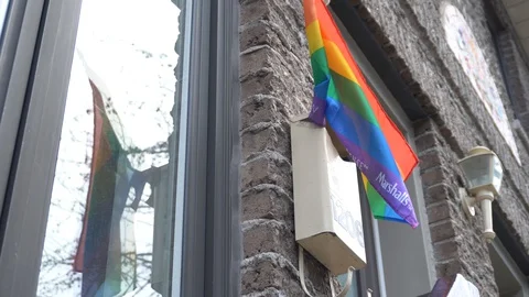 A gay pride flag that reflects on a window 스톡 동영상 129578830