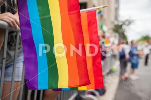 Gay rainbow flags at Montreal gay pride parade with blurred spectators in the Stock Photos