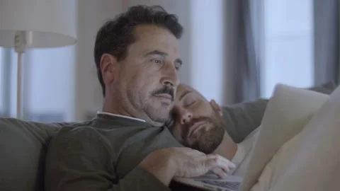 Gay using laptop in bed while his lover sleeping on his shoulder Video stock 229632494