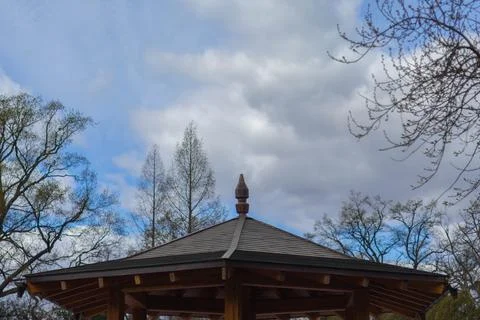 Gazebo structure under cloudy sky in a park setting Stock Photos